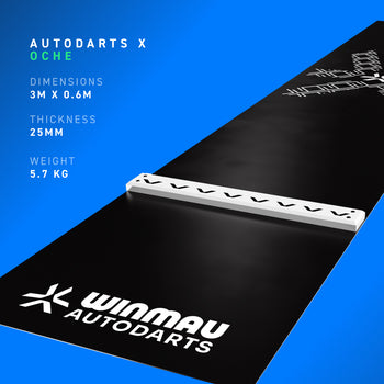 A black Winmau Autodarts official floor mat shown at an angle on a blue gradient background, featuring the white Autodarts logo, a raised white integrated oche bar, and product specifications "dimensions 3m x 0.6m", "thickness 25mm", "weight 5.7kg" on the left.